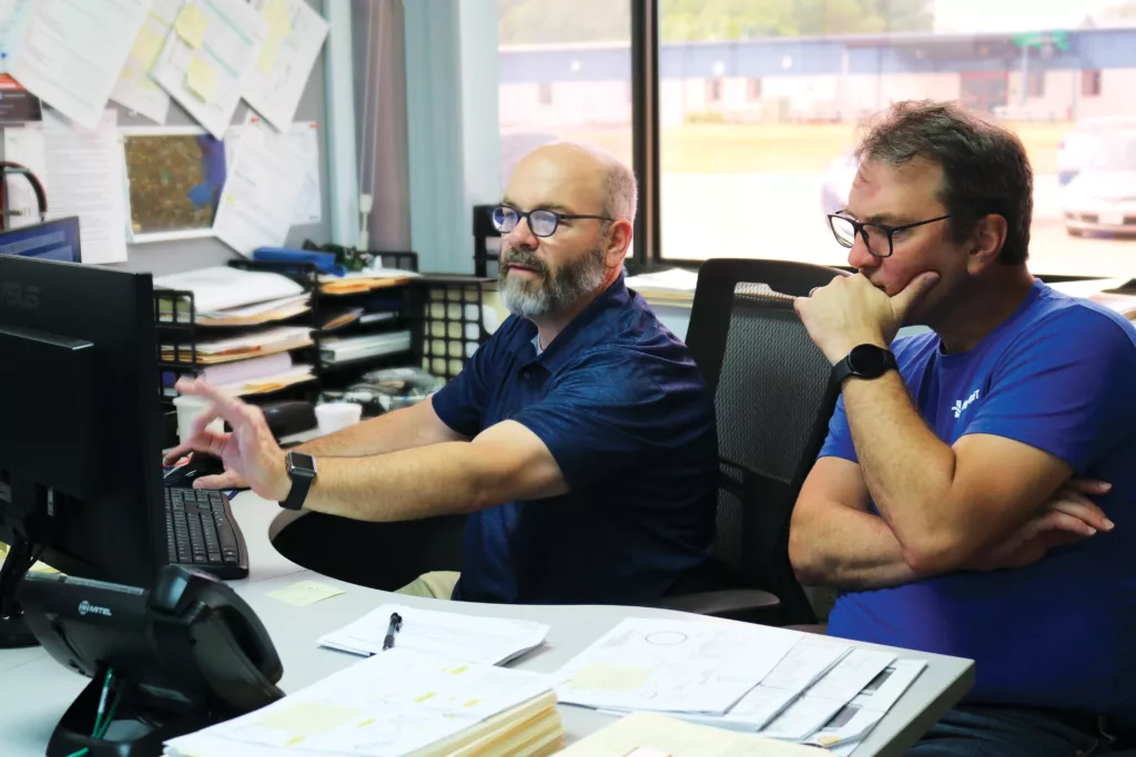 Engineers discussing items on a computer